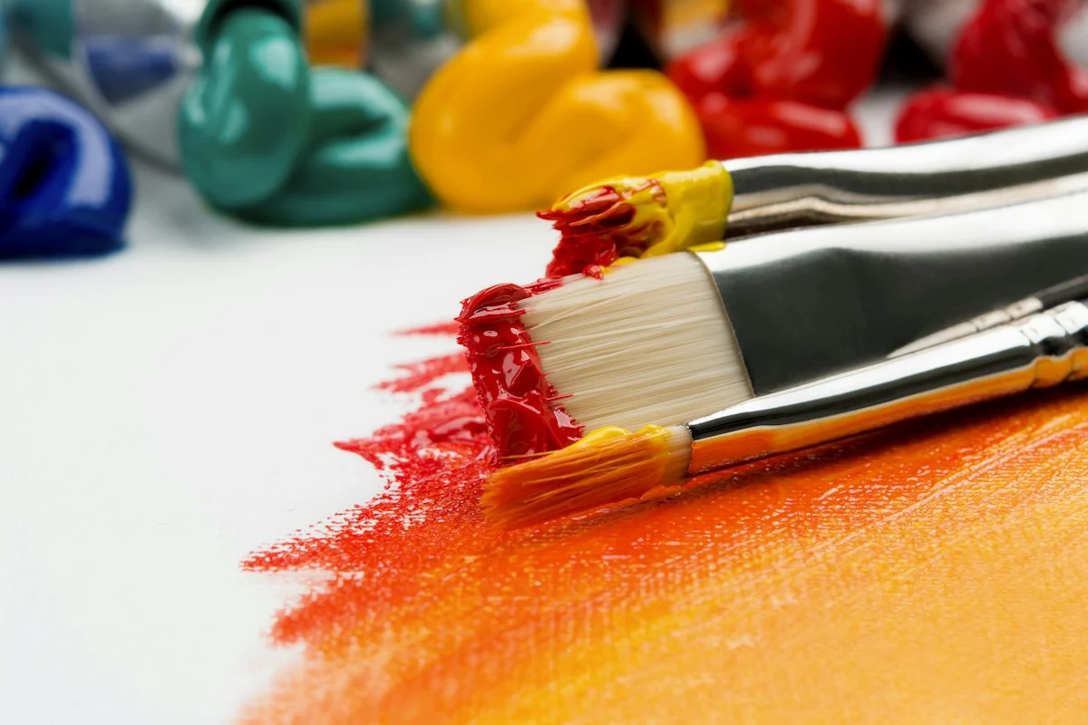Artist brushes covered in colourful acrylic paint